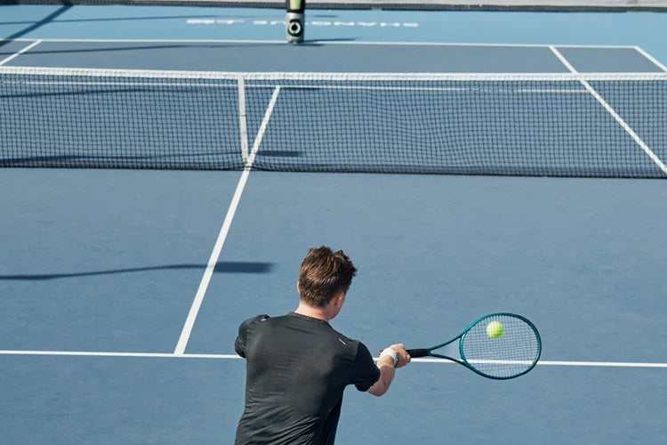 Tennis player practicing a compact return with Lumistar TERO Pro across the net