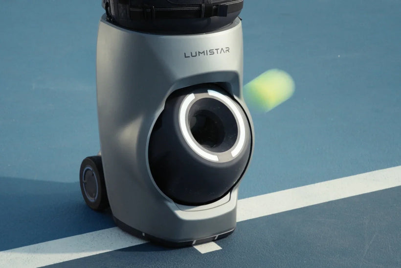 Tennis ball leaving the launcher of a Lumistar TERO Pro on an outdoor court