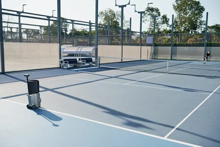 Tennis player practicing across the court from a Lumistar TERO Pro