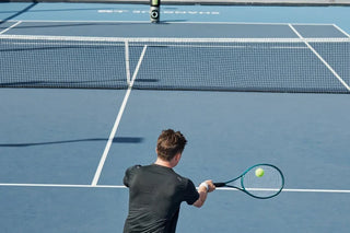 Tennis player practicing a compact return with Lumistar TERO Pro across the net