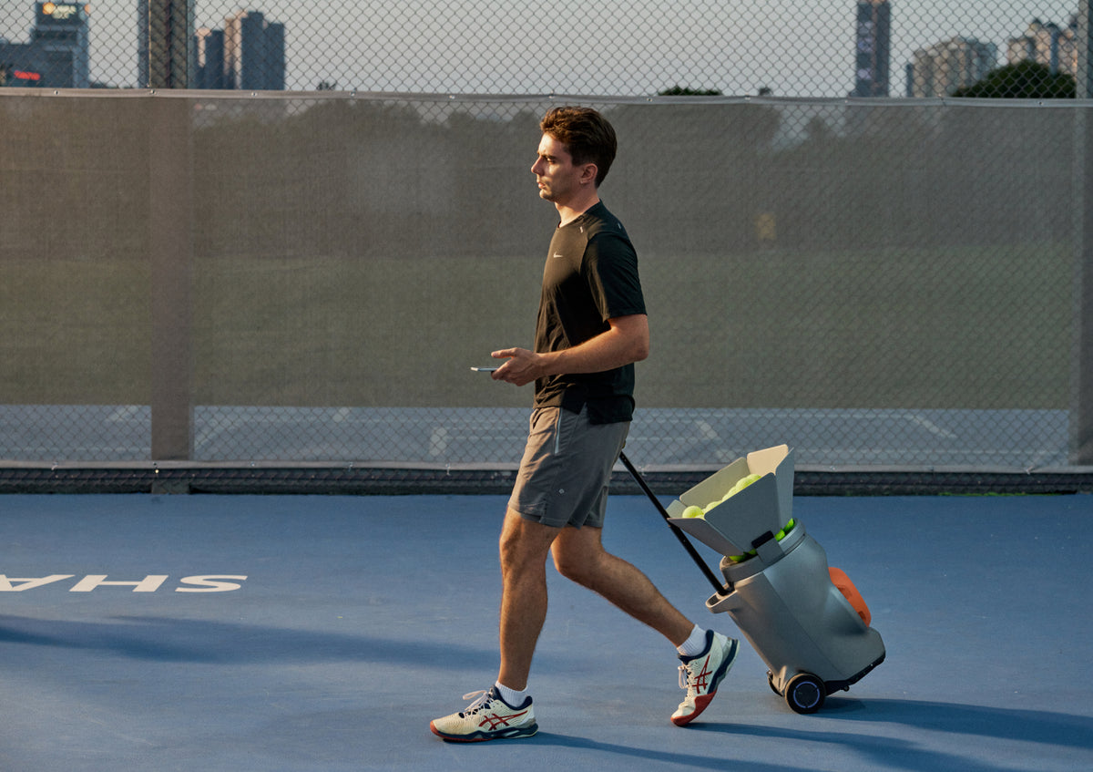 Tennis player rolling a Lumistar TERO across an outdoor court